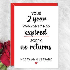 May include: A white greeting card with a red envelope featuring the black text: YOUR 2 year WARRANTY HAS expired. SORRY, no returns. HAPPY ANNIVERSARY. A small red heart is printed below the text, and red roses are visible on the left side.