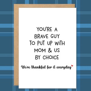 May include: A white greeting card with a brown border. The card features black text that reads "YOU'RE A BRAVE GUY TO PUT UP WITH MOM & US BY CHOICE. We're thankful for it everyday" with a small red heart.