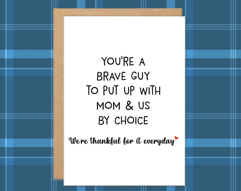 May include: A white greeting card with a brown border. The card features black text that reads "YOU'RE A BRAVE GUY TO PUT UP WITH MOM & US BY CHOICE. We're thankful for it everyday" with a small red heart.