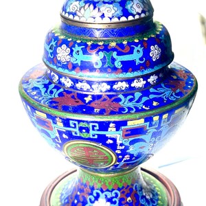 May include: A blue and gold cloisonn&eacute; incense burner with intricate floral and dragon designs. The burner sits on a carved wooden stand.