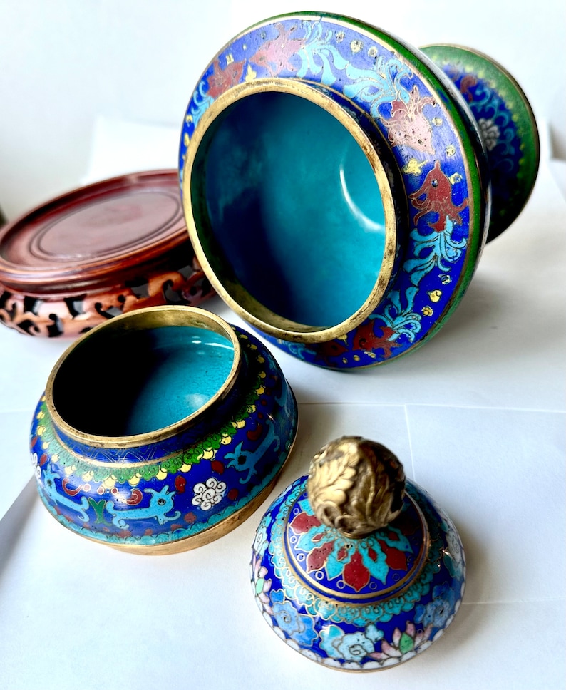 May include: A set of three blue and gold cloisonn&eacute; Chinese incense burners with floral and animal designs. The lid of the burner has a gold finial.