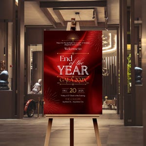 May include: A wooden easel supports a red sign with white text announcing an "End of the Year Gala 202X." The sign includes the date, time, and venue details. The background is a blurred interior with warm lighting.