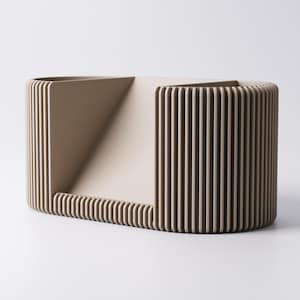 May include: A beige, geometric decorative object with a rectangular base and a curved, ribbed exterior. The design includes a triangular opening and vertical lines, creating a modern, minimalist aesthetic. The object is likely made of a solid material.