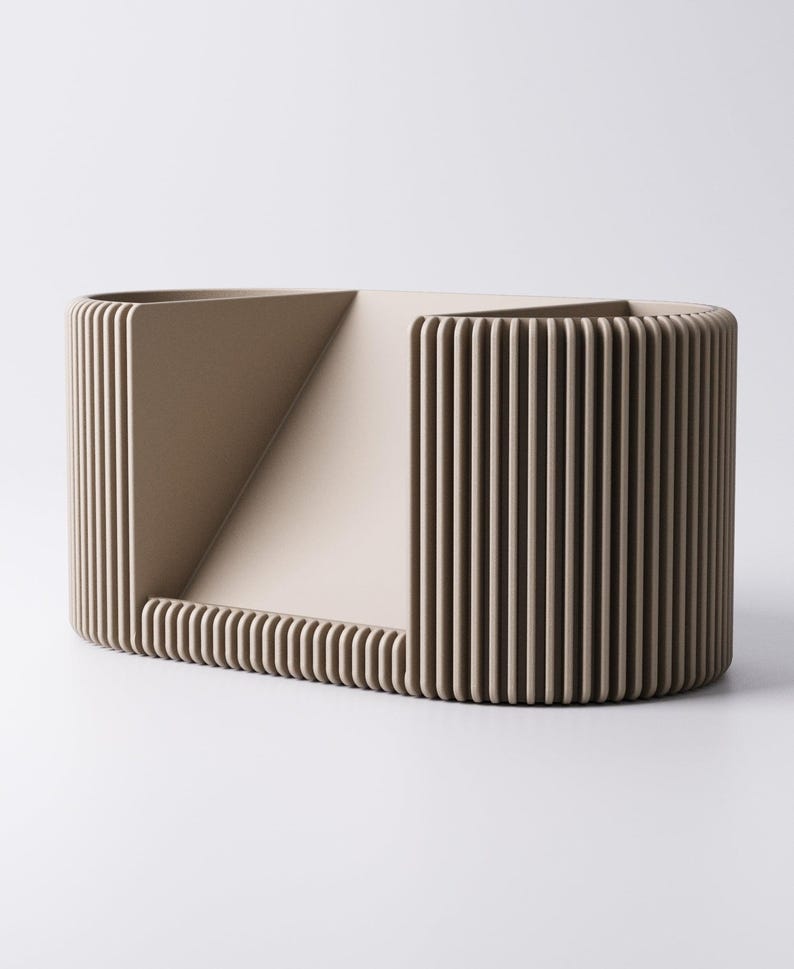 May include: A beige, geometric decorative object with a rectangular base and a curved, ribbed exterior. The design includes a triangular opening and vertical lines, creating a modern, minimalist aesthetic. The object is likely made of a solid material.