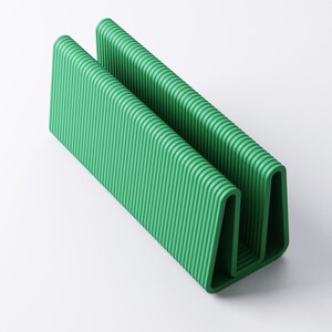 May include: A vibrant green, U-shaped object with a ribbed texture. The design features two parallel, vertical sections connected by a curved base. The object is made of a solid material and is set against a white background.