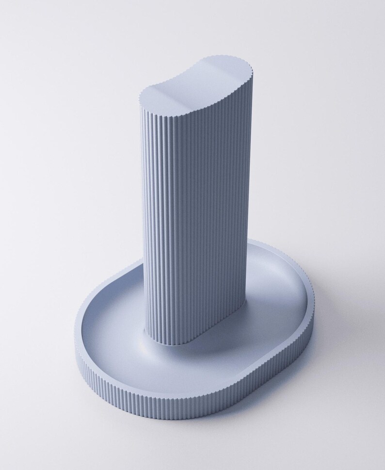 May include: A light periwinkle blue stand featuring a tall, vertical, ribbed cylindrical column with a concave top, mounted on an oval-shaped base with a matching ribbed edge. The entire object has a uniform matte finish and a structured design.