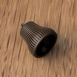May include: A brown, bell-shaped object with vertical, curved lines. The object has a small, rounded top and a wide, open base. The interior is dark. The object is made of a solid material and sits on a wooden surface.