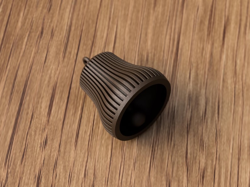 May include: A brown, bell-shaped object with vertical, curved lines. The object has a small, rounded top and a wide, open base. The interior is dark. The object is made of a solid material and sits on a wooden surface.