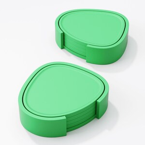 May include: Two sets of green coasters. Each set includes a stack of coasters with a rounded triangular shape and a matching holder. The coasters and holders are a solid, bright green colour, and are set against a white background.