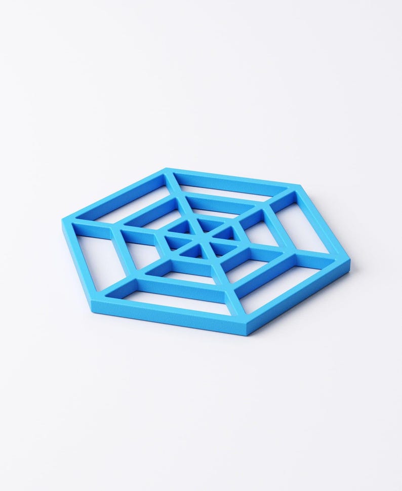 Pu&ograve; includere: Un sottobicchiere geometrico blu brillante a forma esagonale. Il sottobicchiere presenta un design aperto, a forma di ragnatela, con linee intersecanti e motivi triangolari. Il sottobicchiere &egrave; realizzato in materiale solido ed &egrave; su sfondo bianco.