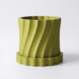 Może przedstawiać: Chartreuse donica o kształcie walca z falistym, spiralnym wzorem. Donica posiada pasujący, karbowany spodek. Donica ma około 18 cm wysokości i 15 cm średnicy, nadaje się do użytku wewnątrz i na zewnątrz.