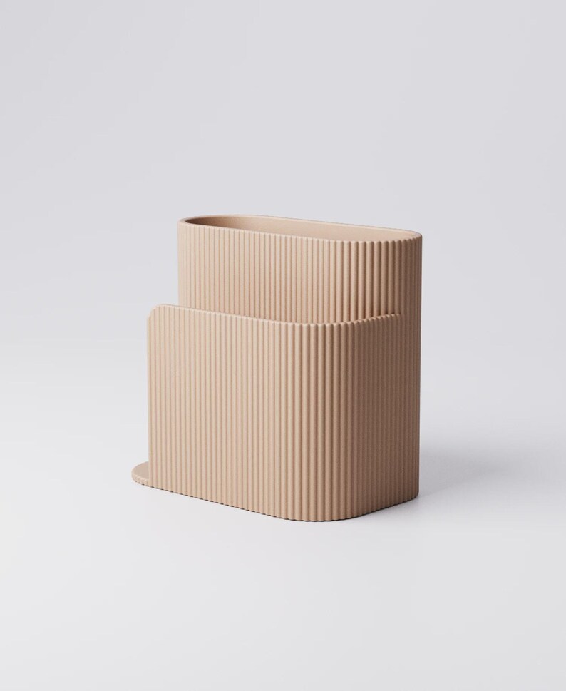 Pu&ograve; includere: Un contenitore rettangolare beige e scanalato con una parte superiore arrotondata e un contenitore pi&ugrave; piccolo e abbinato all'interno. I contenitori hanno una texture verticale ondulata e poggiano su una base piatta. Lo sfondo &egrave; bianco.