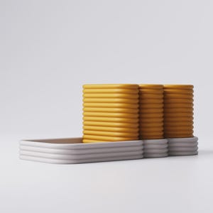 Puede incluir: Dise&ntilde;o moderno y minimalista con tres pilas de objetos rectangulares amarillos y acanalados, apoyados sobre una bandeja rectangular gris claro. Los objetos tienen un aspecto liso y redondeado, creando una est&eacute;tica limpia y contempor&aacute;nea.