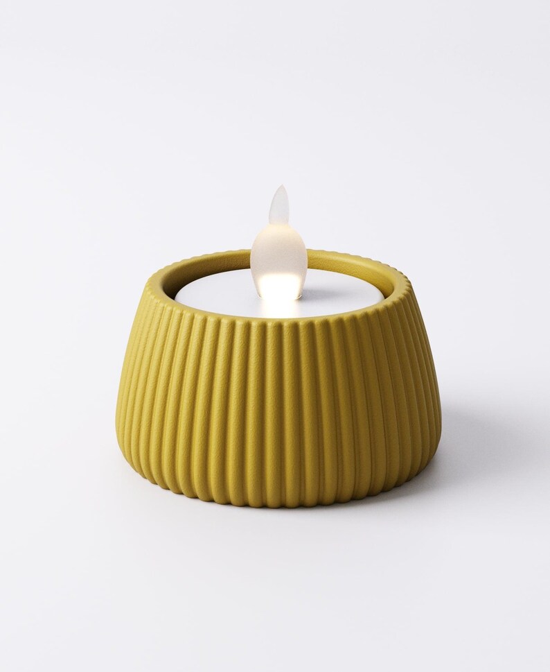 May include: A yellow, ribbed, battery-operated candle with a white interior and a flickering, flame-shaped light. The candle has a rounded, flared shape and is designed to resemble a traditional candle.