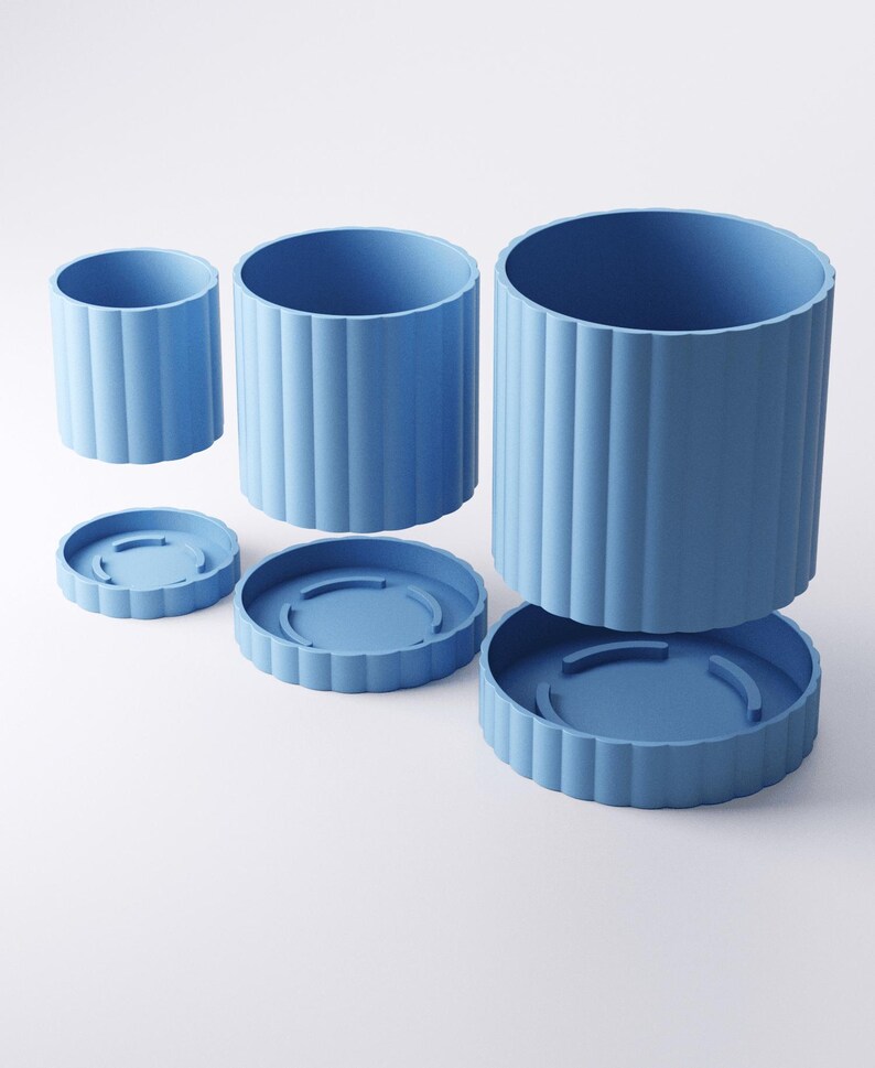 May include: Three blue cylindrical planters of varying sizes, each with a matching saucer. The planters have a ribbed design and are arranged against a white background. The largest planter is approximately 7 inches tall and 6 inches in diameter.