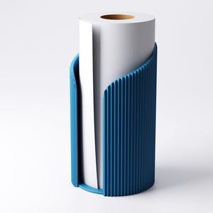 May include: A white paper roll is held within a blue, vertically ribbed holder. The holder has a curved design, with a rounded base and open sides to display the paper. The paper roll has a brown cardboard core.