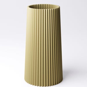 May include: A tall, olive-green vase with a ribbed, vertical design. The vase has a cylindrical shape with a slightly flared base and a wide opening at the top. The ribbed texture adds visual interest to the minimalist design.