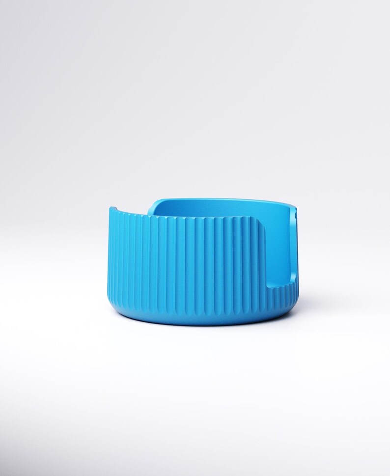 May include: A vibrant blue, modern-style container with a rounded base and vertical ridged detailing on the front. The container has a curved opening on one side and a smooth, flat back. The object is set against a plain white background.
