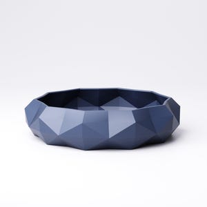 Puede incluir: Un cuenco geom&eacute;trico facetado en un tono azul apagado. El cuenco tiene un perfil bajo con una forma irregular y multifac&eacute;tica. La superficie es mate y parece estar hecho de un material s&oacute;lido. El dise&ntilde;o es moderno y minimalista.