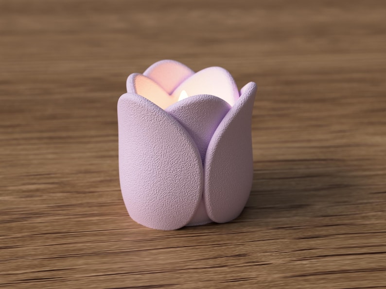 May include: A lavender-colored tulip-shaped candle holder with a textured surface. The candle holder has a soft, matte finish and is designed to resemble a blooming tulip. The interior glows with a warm, inviting light.