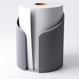 May include: A contemporary grey toilet roll holder with a vertical ribbed pattern. It encases a white toilet roll, with some paper visible. The design is minimalist and modern, suitable for a bathroom.