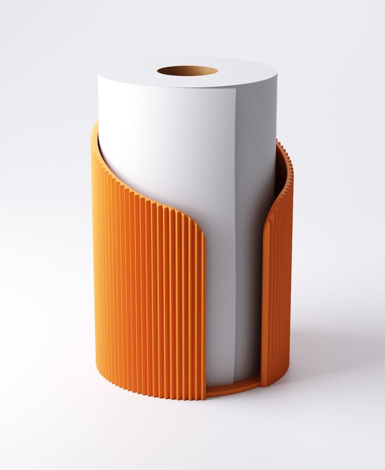 May include: An orange paper towel holder with a vertical ribbed design. The holder has a curved shape that partially wraps around a roll of white paper towels. The design is modern and minimalist, suitable for a kitchen or bathroom.