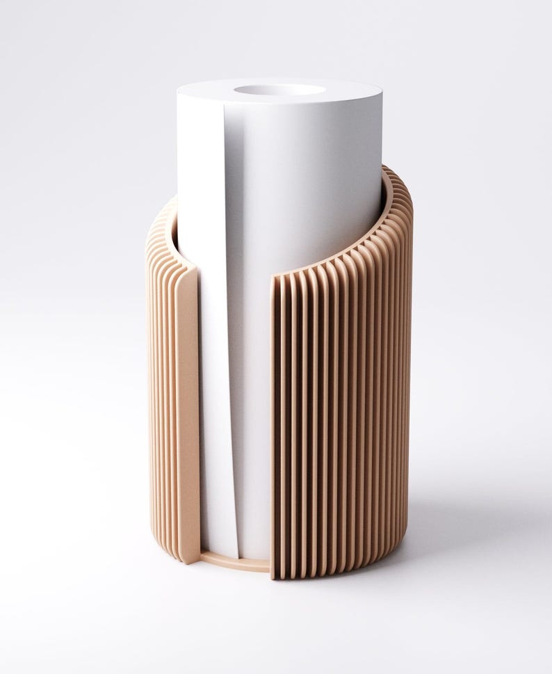 May include: A modern, minimalist toilet paper holder. The design features a cylindrical white paper roll partially encased by a light brown, vertically slatted wooden structure. The holder has a clean, contemporary aesthetic.