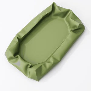 May include: An olive green rectangular tray with raised edges. The tray has a smooth, matte finish and appears to be made of a flexible material. The edges are folded over, creating a defined border.