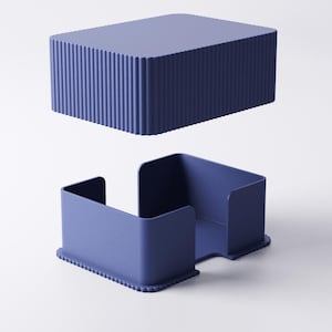 May include: Two-piece, navy blue container set. The top piece is a rectangular box with vertical ridged sides. The bottom piece is a tray with a cutout and a ridged base. The set is made of a solid, matte material.