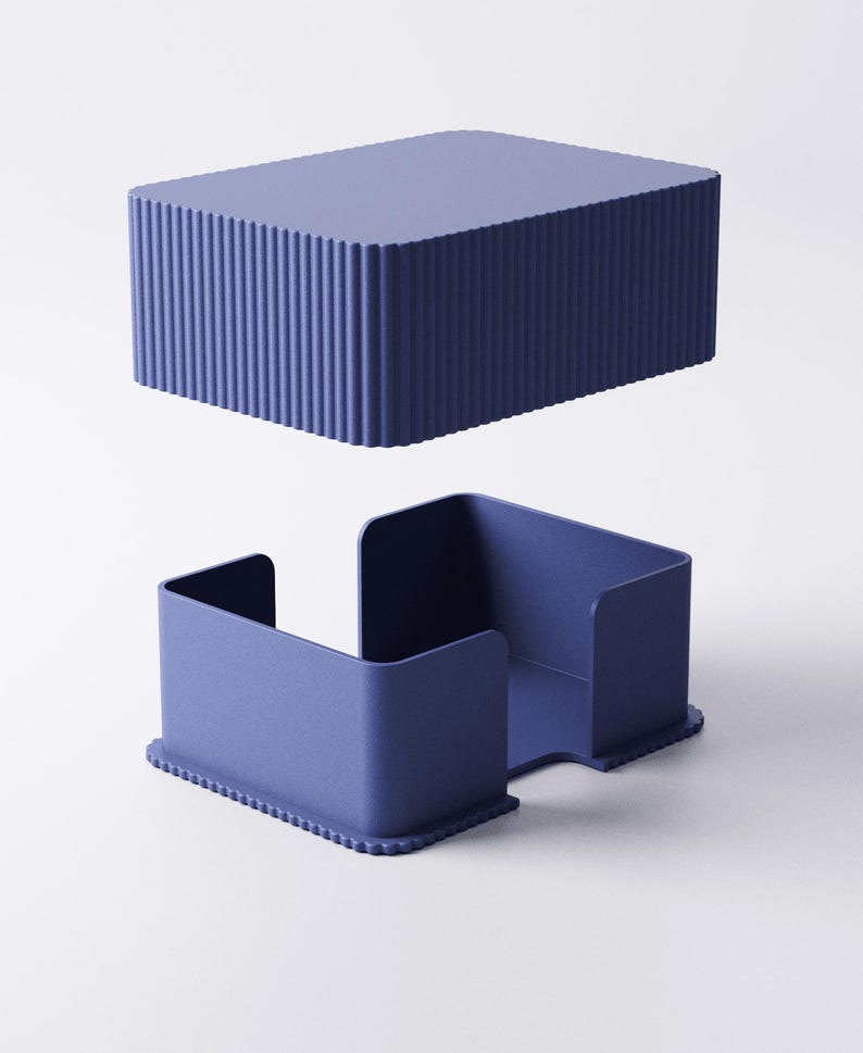 May include: Two-piece, navy blue container set. The top piece is a rectangular box with vertical ridged sides. The bottom piece is a tray with a cutout and a ridged base. The set is made of a solid, matte material.