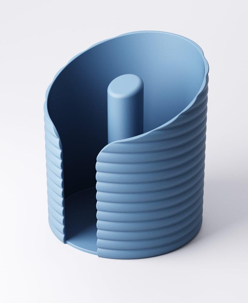 May include: A blue paper towel holder with a cylindrical center post. The holder has a curved, ridged exterior and a rounded opening. The design is modern and minimalist, with a solid blue color.