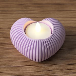 May include: A heart-shaped, lavender candle holder with vertical grooves. The holder contains a lit, white candle. The candle holder is on a wooden surface.