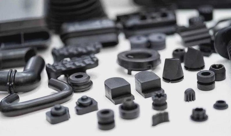 May include: An assortment of black rubber parts, including tubes, seals, and various shaped components. The collection features a variety of sizes and designs, suitable for industrial or mechanical applications. The parts are arranged on a white surface.