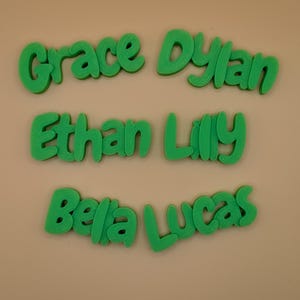 May include: Green 3D printed names: Grace, Dylan, Ethan, Lilly, Bella, and Lucas. The names are in a playful, rounded font, and are arranged on a neutral background. Suitable for personalized gifts or room decor.