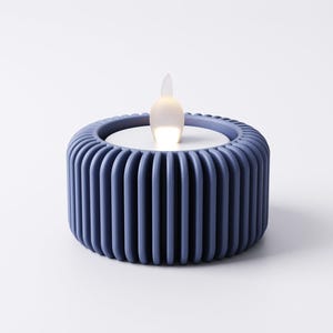 May include: A blue LED candle with a ribbed, cylindrical base. The candle has a white top and a flickering, flame-shaped light. The design is modern and minimalist, suitable for home decor.