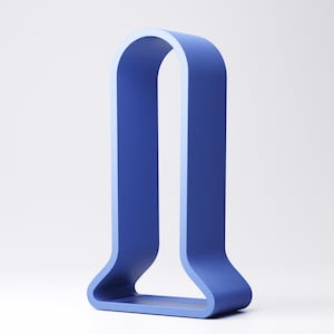 Peut inclure: Un objet d&eacute;coratif bleu moderne en forme de U. L'objet pr&eacute;sente une surface textur&eacute;e avec des lignes verticales et un int&eacute;rieur bleu clair. La base est un rectangle plein.