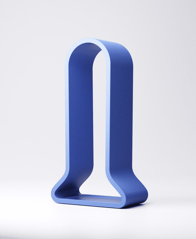 Peut inclure: Un objet d&eacute;coratif bleu moderne en forme de U. L'objet pr&eacute;sente une surface textur&eacute;e avec des lignes verticales et un int&eacute;rieur bleu clair. La base est un rectangle plein.