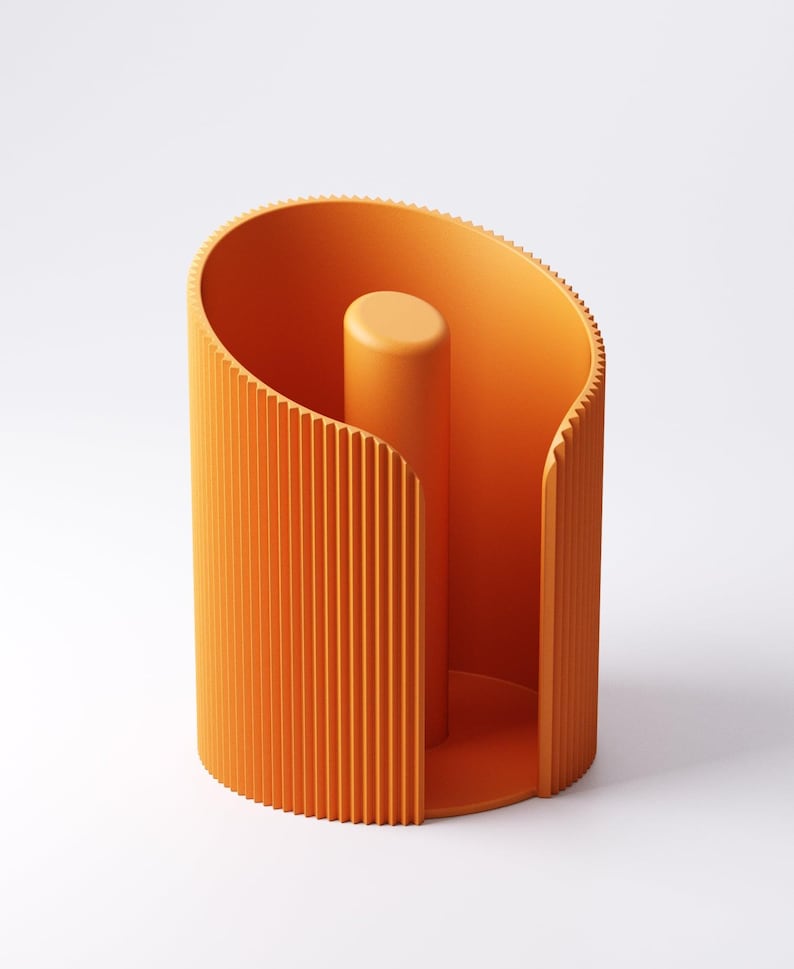 May include: An orange paper towel holder with a vertical, ribbed design on the exterior. The holder has a cylindrical shape with a central post for the paper towel roll. The design is modern and minimalist.