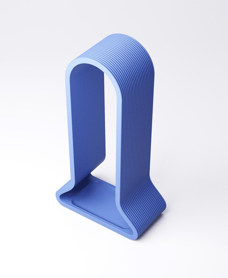 Peut inclure: Une sculpture bleue moderne et minimaliste en forme de U. Elle pr&eacute;sente une base rectangulaire et un sommet incurv&eacute;, avec des rainures verticales sur les bords ext&eacute;rieurs. La couleur est un bleu moyen uni.