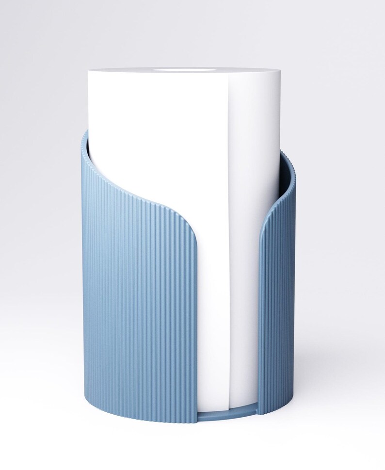 K&ouml;nnte beinhalten: Ein hellblaues, zylindrisches Papiertuchhalter mit vertikalen Rippendetails. Der Halter hat eine geschwungene &Ouml;ffnung und h&auml;lt eine Rolle wei&szlig;er Papiert&uuml;cher. Das Design ist modern und minimalistisch.