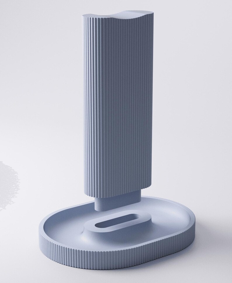 May include: A light blue vertical stand featuring a tall, rectangular column with a ribbed texture and a concave top. The column is attached to an oval-shaped base that includes a central, elongated, recessed slot and a matching ribbed outer edge.