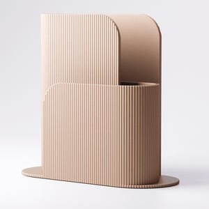 May include: A contemporary, beige vase with a ribbed texture. The vase features a distinctive, curved design with a rounded top and a circular base. The vertical lines create a sense of height and elegance. The vase is likely made of ceramic or a similar material.