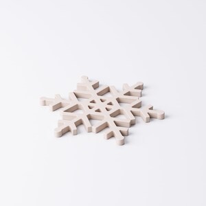 May include: A light beige snowflake-shaped decorative item. The snowflake has six symmetrical arms with intricate cut-out details. The item is made of a solid material and is set against a white background. Ideal for winter holiday decor.