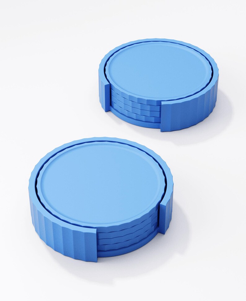 May include: Two stacks of blue coasters. Each coaster has a round, flat top and a ridged, cylindrical edge. The coasters are a light blue color and appear to be made of a solid material.