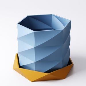 May include: A geometric, blue planter with a matching yellow base. The planter has a faceted design, with a twisted appearance. The base is a contrasting yellow color, and the overall design is modern and minimalist. The planter is suitable for indoor or outdoor use.