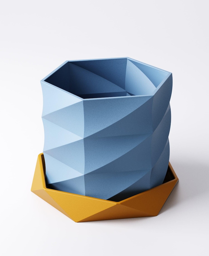 May include: A geometric, blue planter with a matching yellow base. The planter has a faceted design, with a twisted appearance. The base is a contrasting yellow color, and the overall design is modern and minimalist. The planter is suitable for indoor or outdoor use.