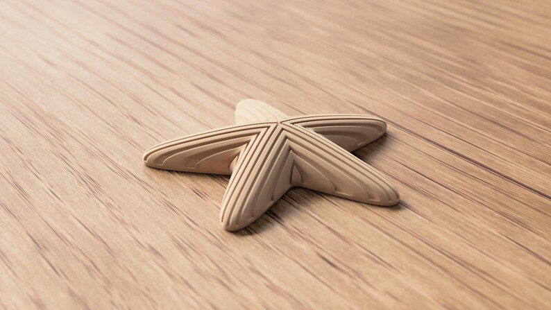 May include: A light-colored wooden starfish with detailed grooves, resting on a wooden surface. The starfish is a decorative item, possibly for coastal or nautical-themed decor.