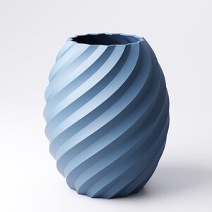 May include: A blue vase with a spiral design. The vase has a textured surface and a wide opening. The color of the vase is a gradient of blue shades, creating a modern and stylish look. The vase is suitable for home decor.
