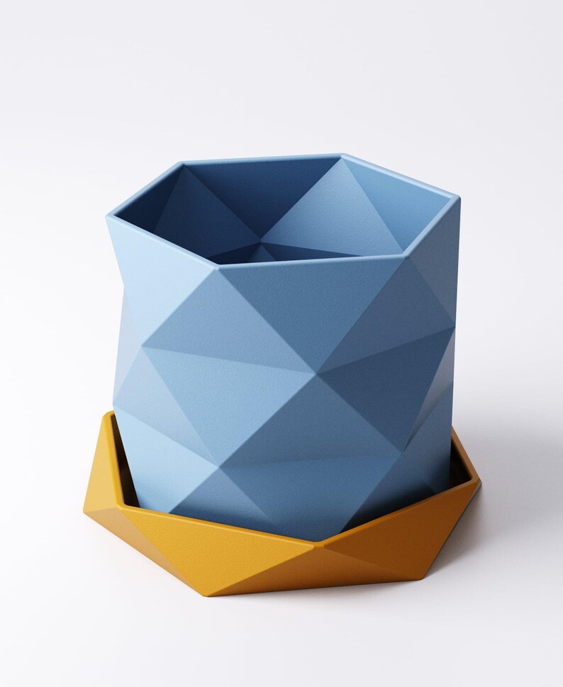 May include: A geometric, blue planter with a matching yellow base. The planter has a faceted design, creating a modern and stylish look. The planter is designed to hold plants and flowers. The planter is made of a durable material.