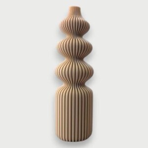 May include: A tall, decorative vase with a unique, layered design. The vase is made of light-colored wood and features a series of rounded, stacked sections, creating an organic, sculptural form. The vertical lines give it a textured appearance.